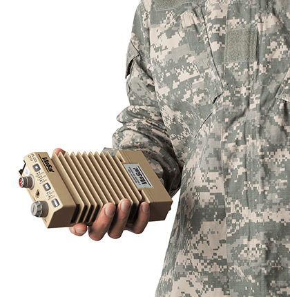 Close up of a person in an army uniform holding a tan IPS-250X Ethernet Encryptor
