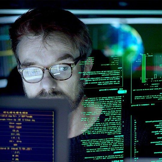 Man looking at a string of code on a computer screen